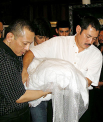 Sigit dan Bambang mengangkut djenazah ibu mereka jang terus tertutup Sigit dan Bambang mengangkut djenazah ibu mereka jang terus tertutup